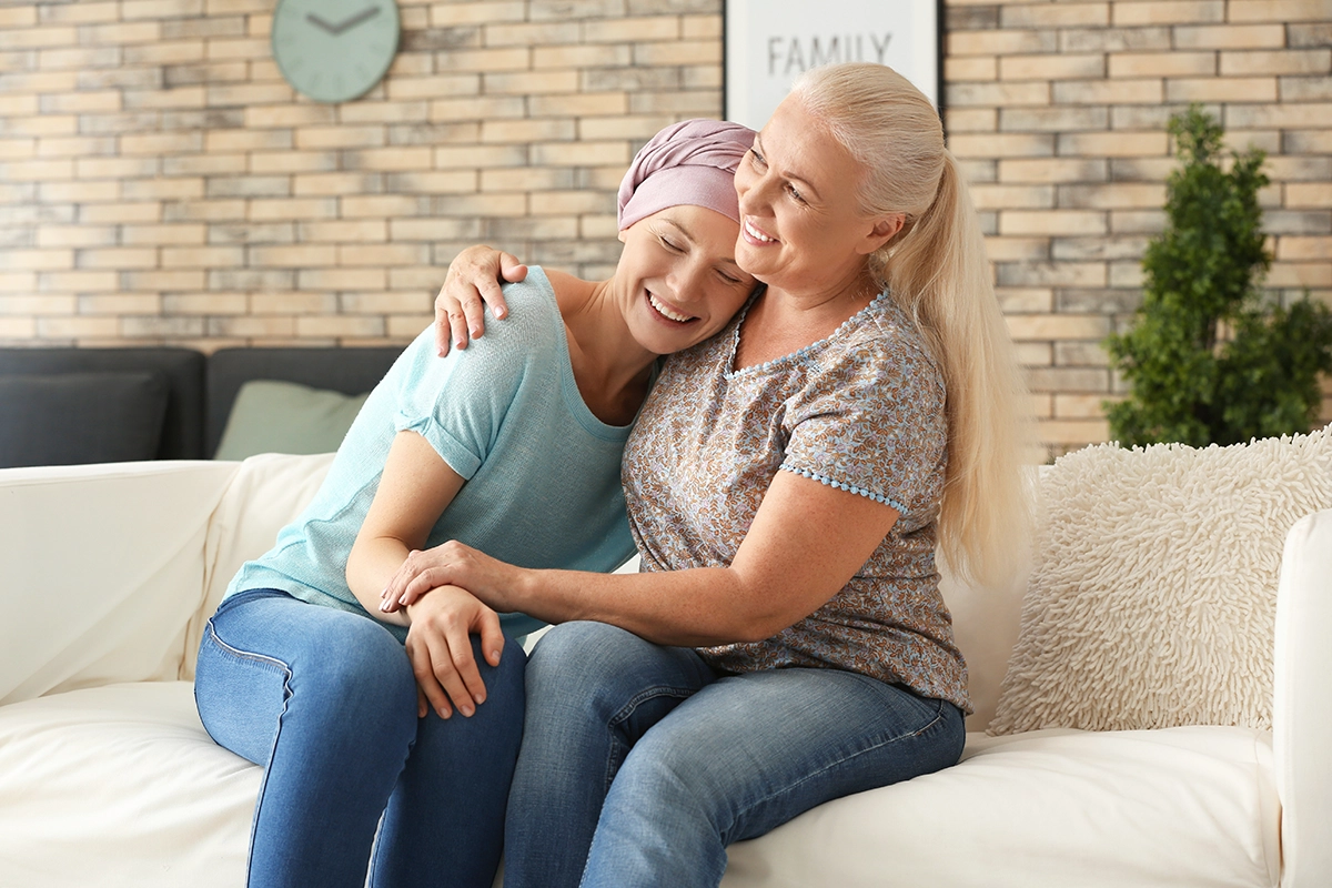 Image of a woman with cancer being supported by another woman